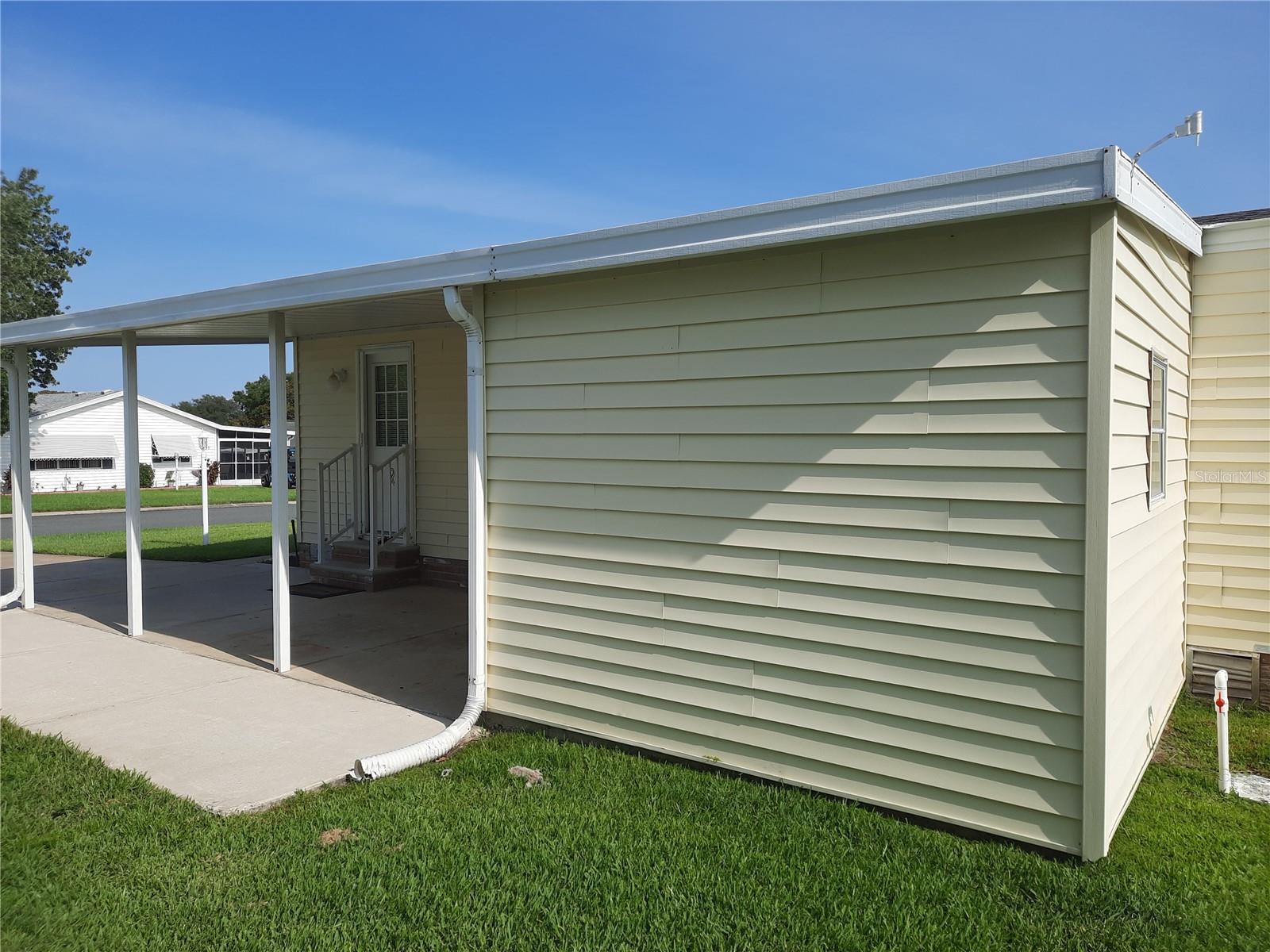 Side house view of storage room and carport