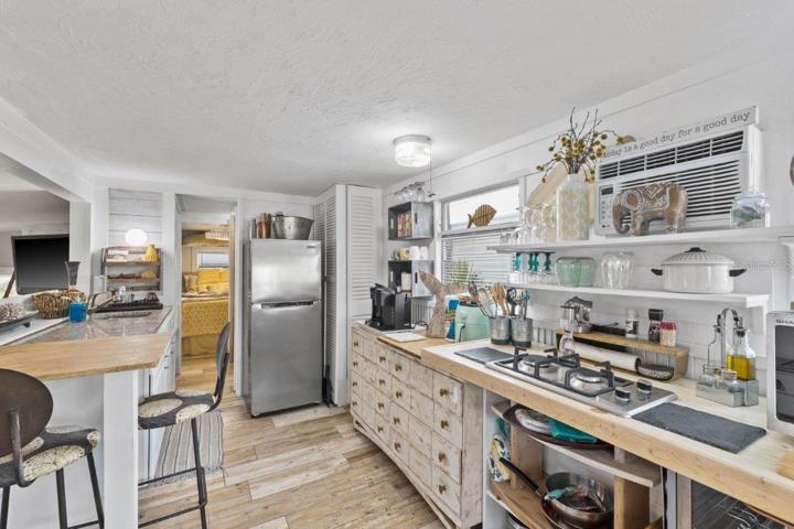 Kitchen featuring granite counter tops, gas stove, and wood look tile.