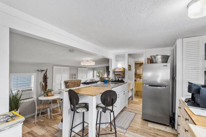 Kitchen featuring granite counter tops, gas stove, and wood look tile.