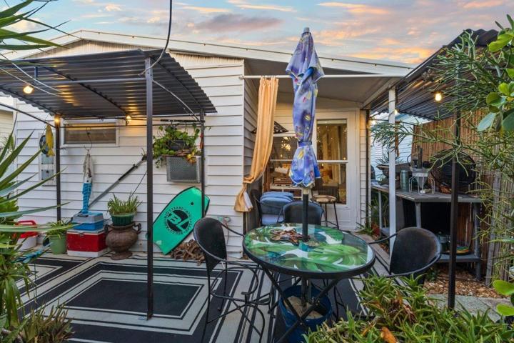 Back lanai featuring mature landscaping, and a outdoor full bathroom and laundry