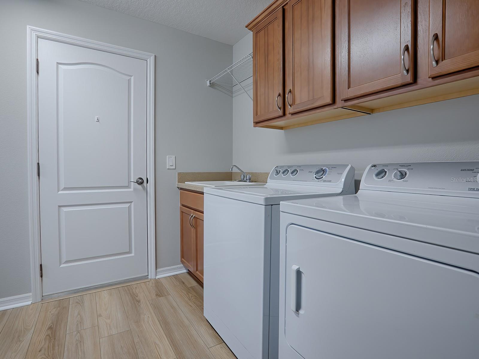 SPACIOUS LAUNDRY ROOM WITH WASHER AND DRYER THAT DO CONVEY WITH THE HOME, DEEP SOAKING SINK, AND ADDITIONAL CABINETS FOR MORE STORAGE!