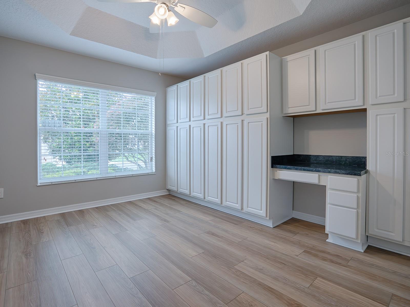 FRONT GUEST BEDROOM WITH TRAY CEILING, AND A FULL WALL OF BUILT IN CABINETS AND DESK!