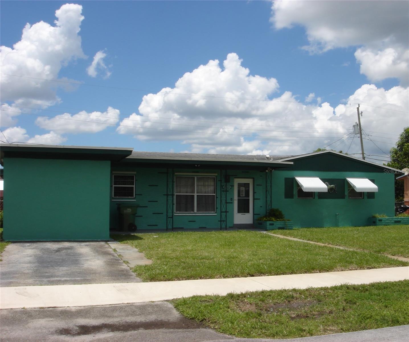 Front Exterior of Home. Driveway for auto. Garage converted to Bonus Room. A/C Wall Unit.
