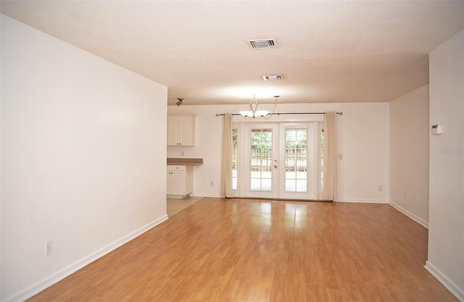 Open layout living room. French doors open to outside covered patio. Fresh white paint throughout the house