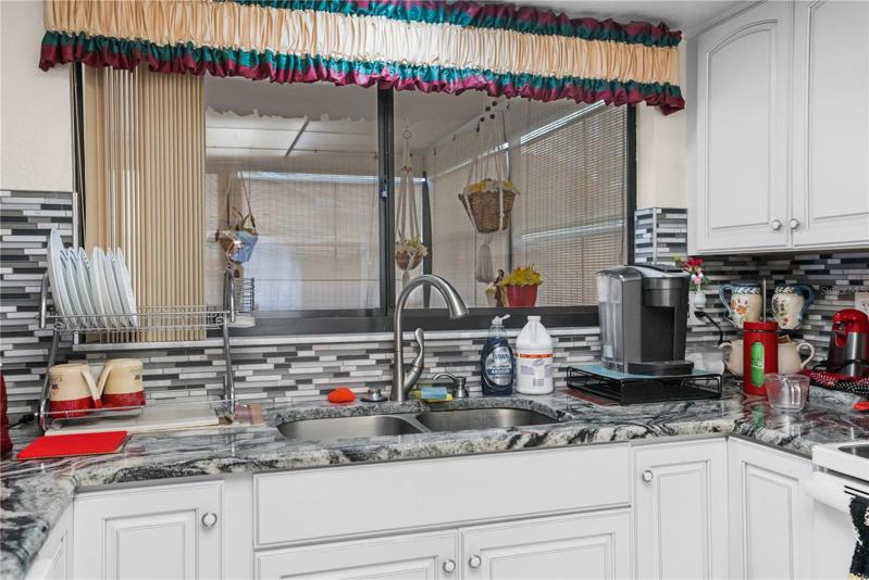 The Window over the Kitchen Sink opens into the Enclosed Porch, perfect to Pass food and drinks to your guests