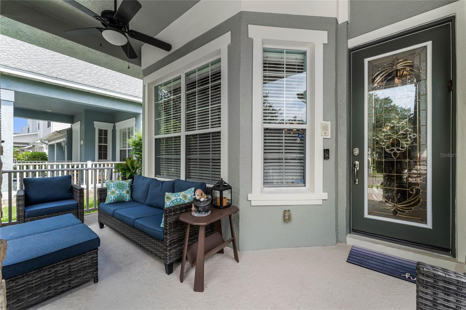 The cozy front porch features a ceiling fan.