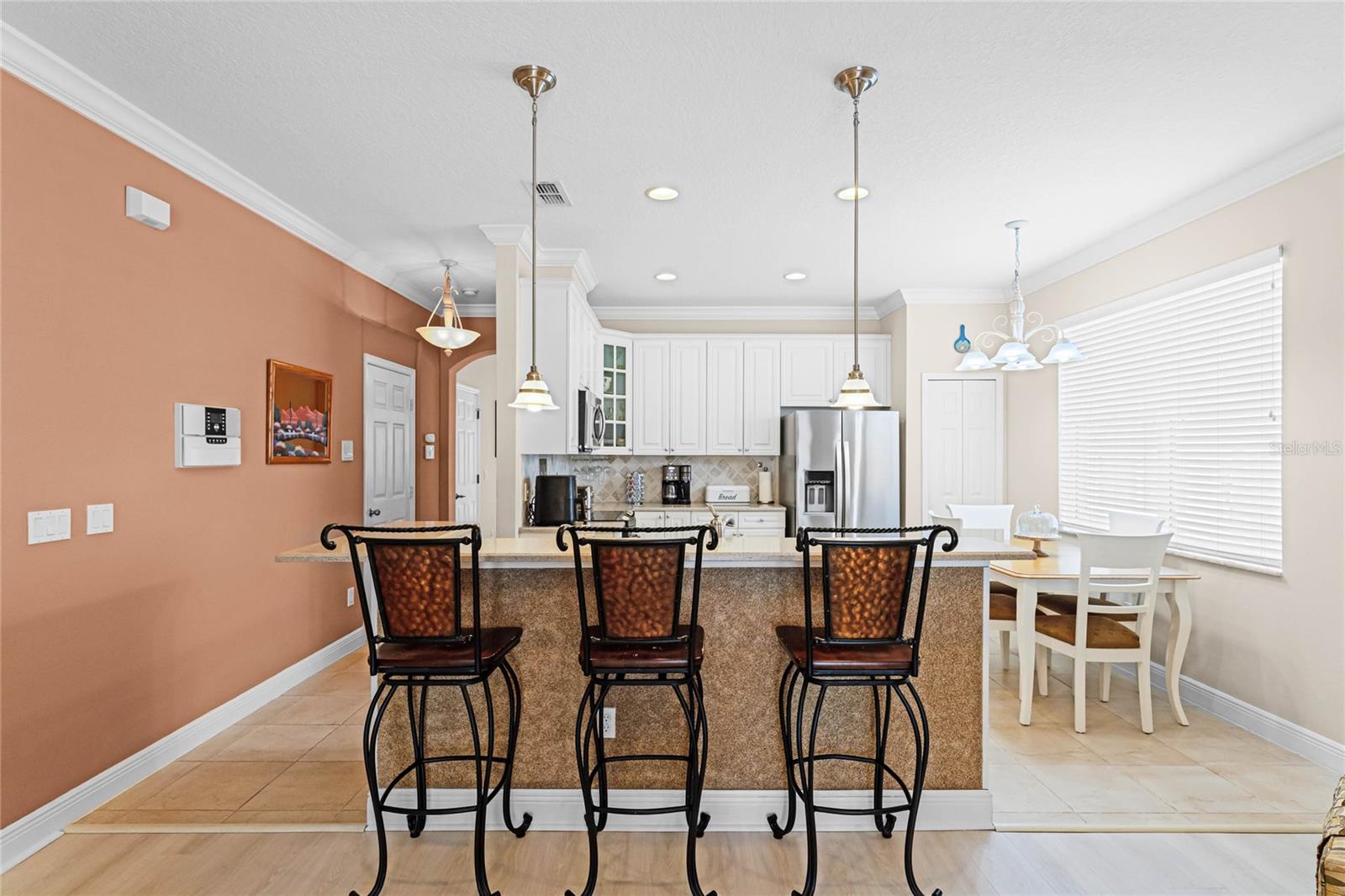 The kitchen features a breakfast bar with pendant lighting.