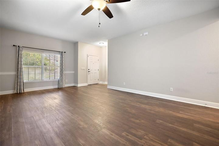 Open living-dining room with easy care laminate flooring ~