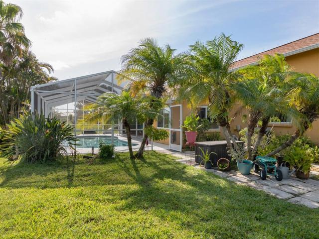 Mature tropical Florida foliage In private fenced garden area to side of pool and in back yard area.