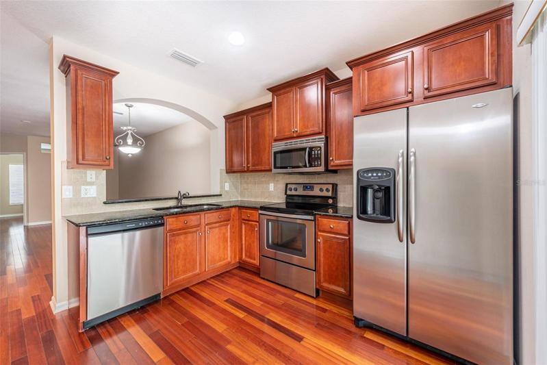 The cherry wood flooring carries through to the kitchen with pass thru window and breakfast bar.
