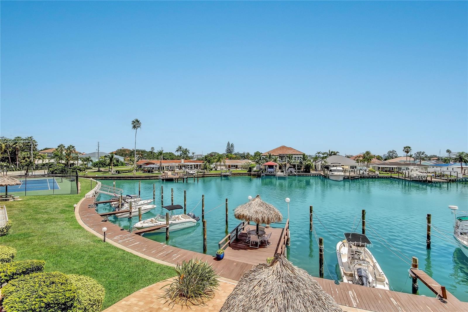Resort style building with heated pool, spa, restrooms, sauna, kayak storage, tennis, shuffleboard, marina and tiki bar.