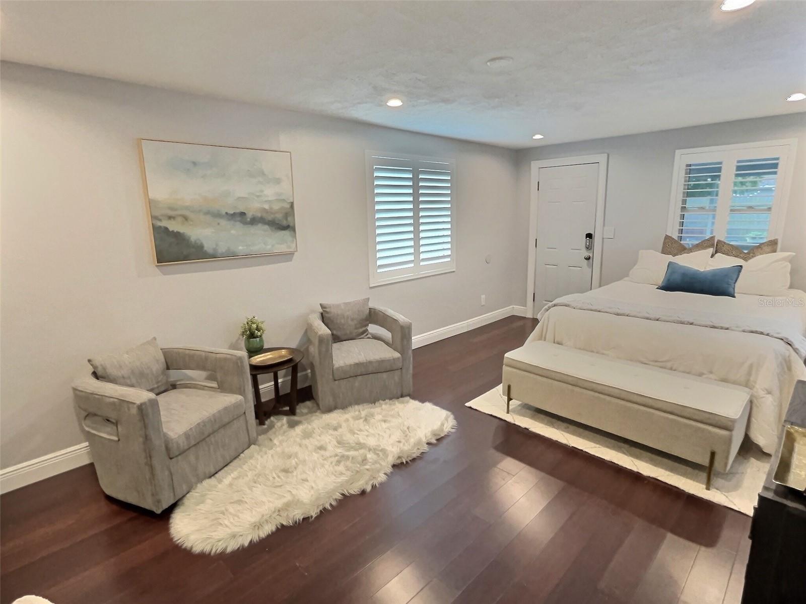 Primary suite with sitting area and exit to screened porch.