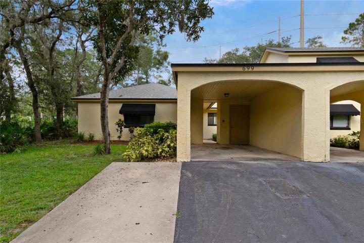 Front of half duplex unit with carport and driveway