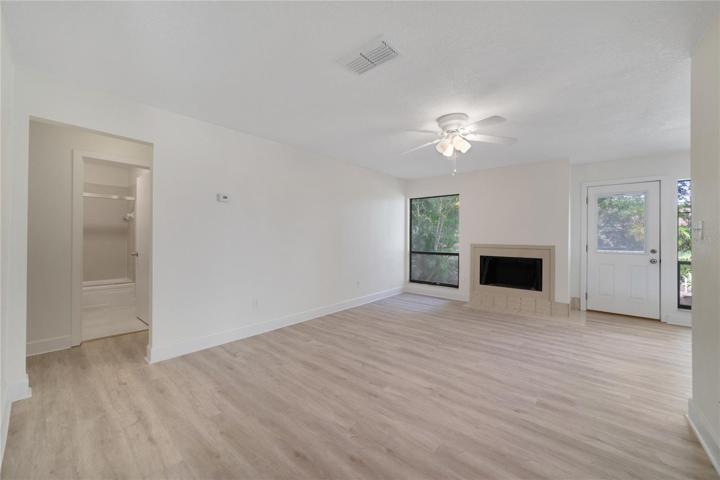 Living room with LVP flooring and wood burning fireplace