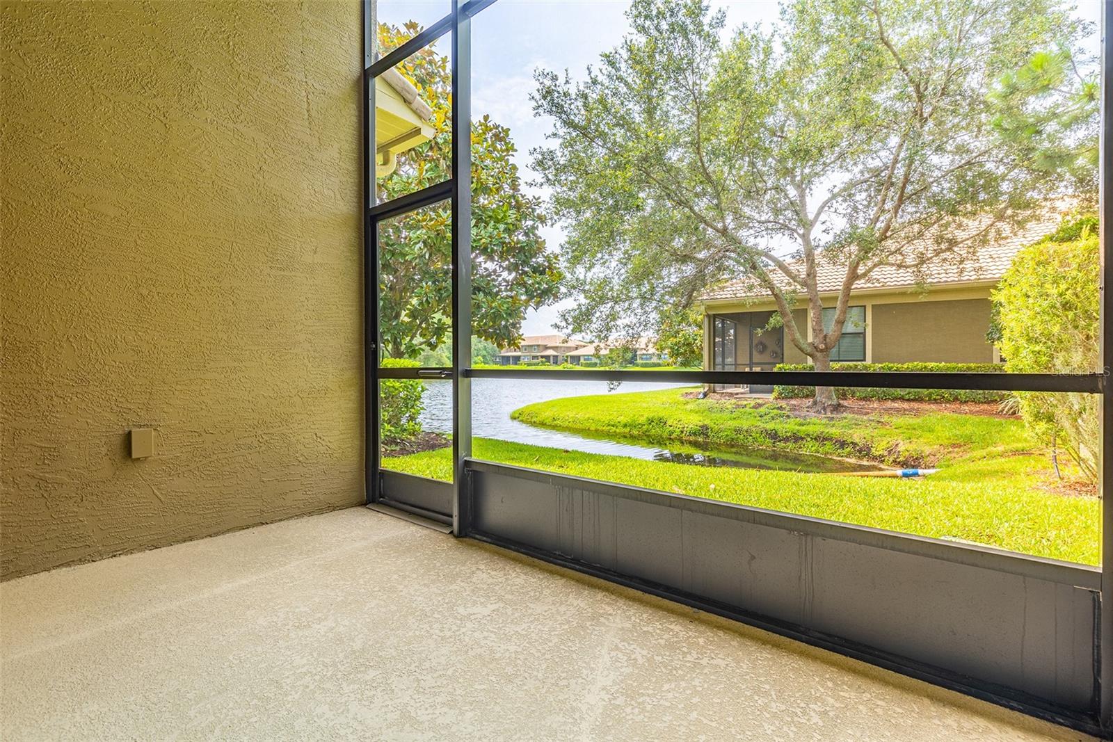 Serene screen enclosed patio with pond view