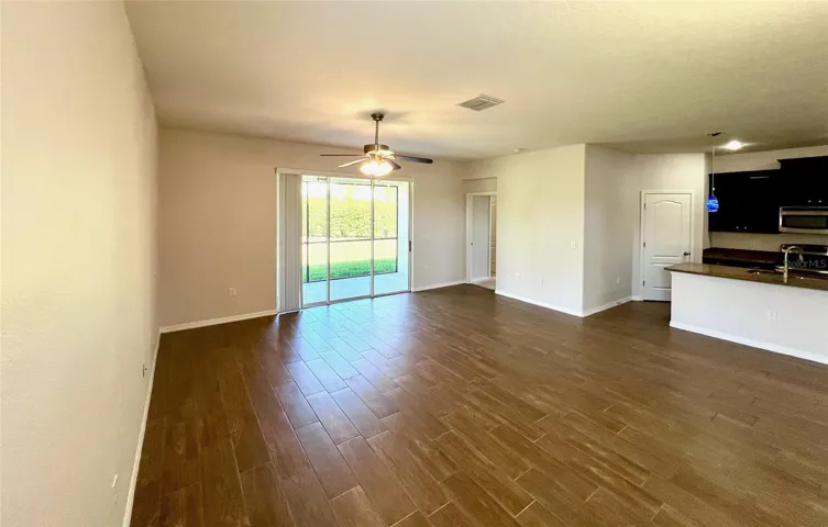 Triple sliders reveal lanai leading to huge backyard