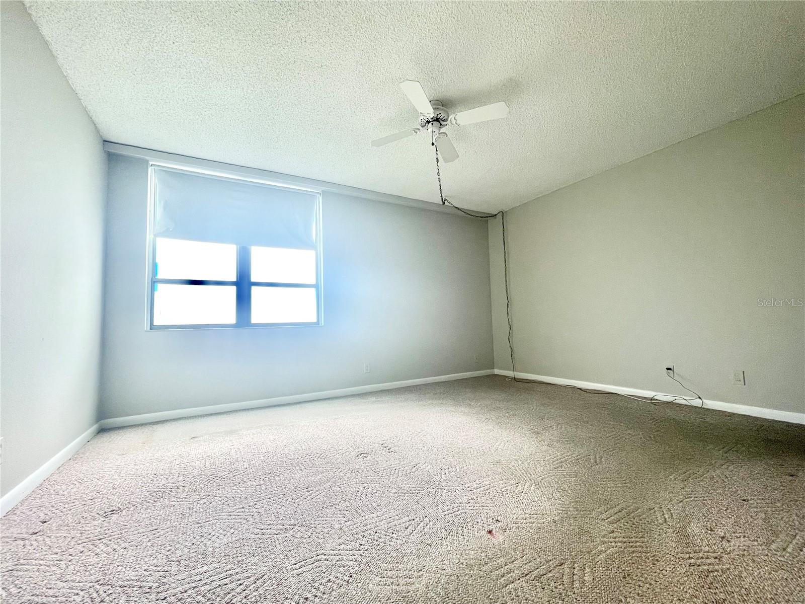 Primary bedroom with ceiling fan.