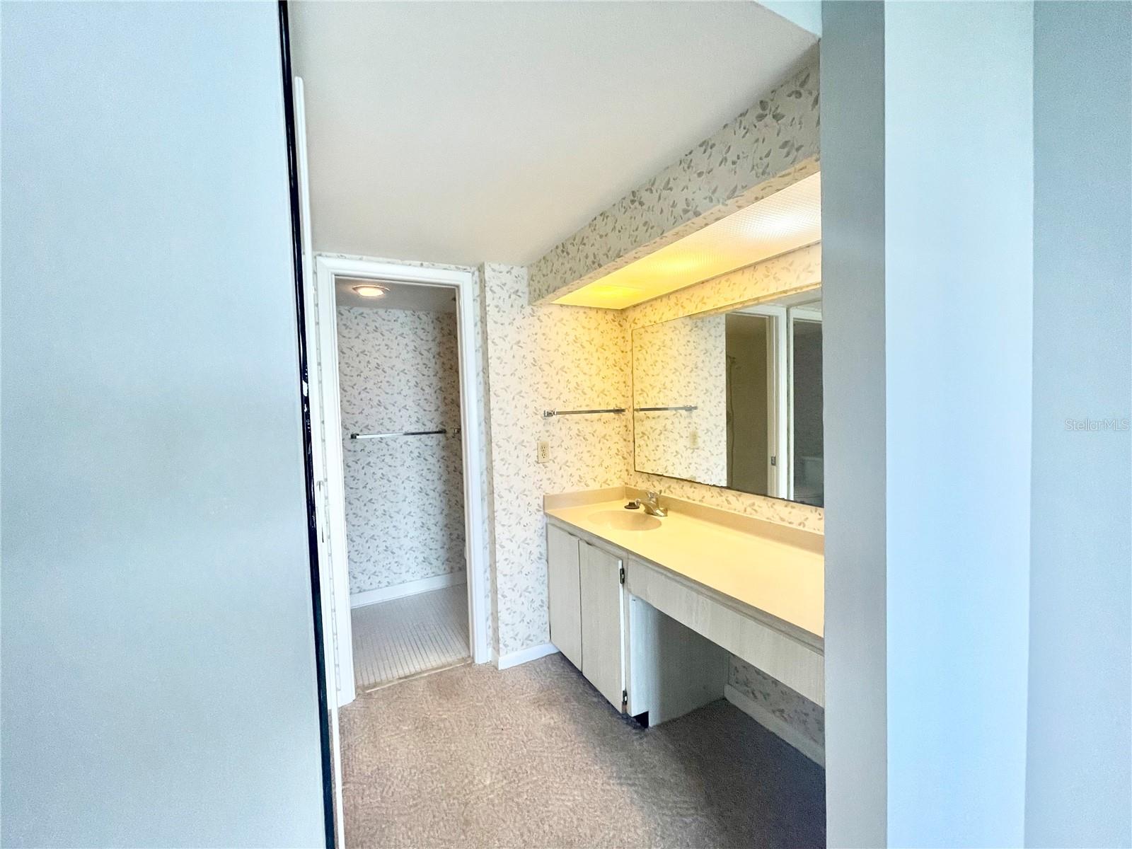 Primary En-Suite Bathroom w walkin shower and dressing table and sink in separate room w walk in closet for privacy.