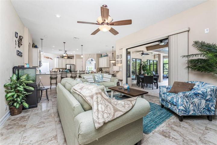 Open concept family, kitchen and dining leads to lanai and pool