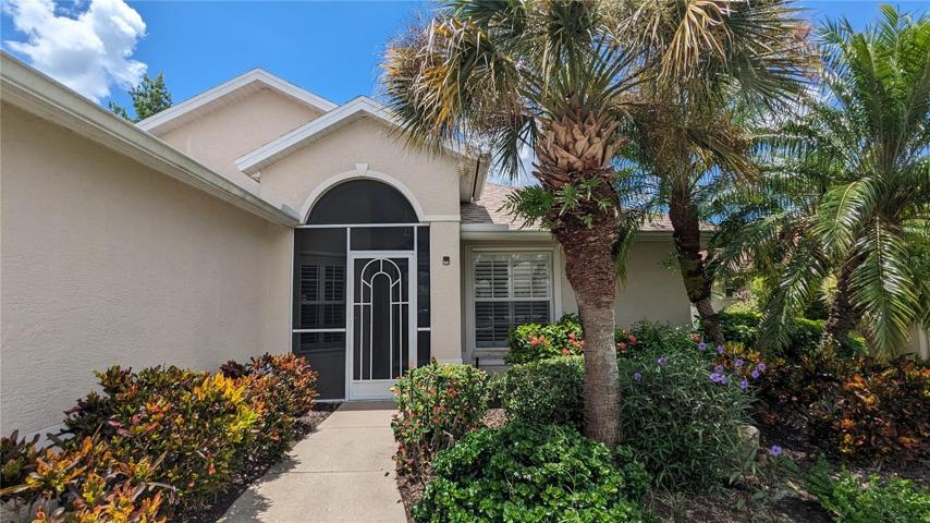 Front of home with lush plantings and screened entrance