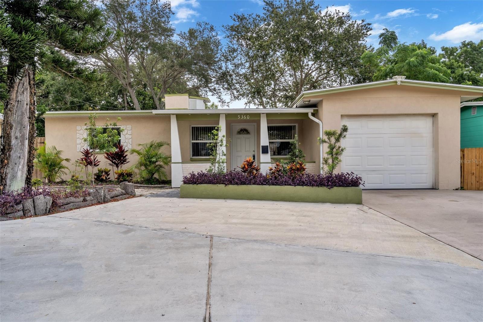 Front with large circular driveway/parking pad and one car garage