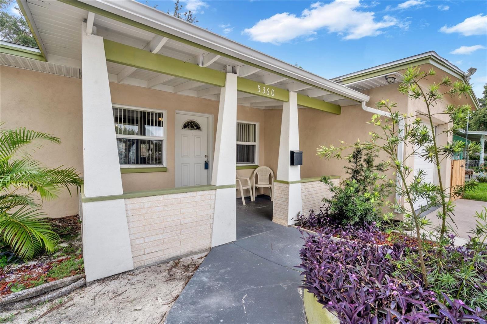 Cute cover front porch with rain gutters and low maintenance yard