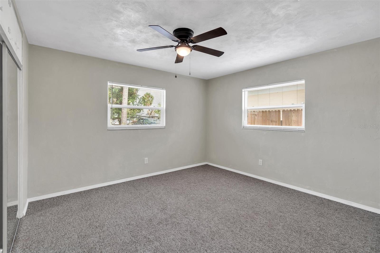Large bedroom 2 with brand new carpet and ceiling fan