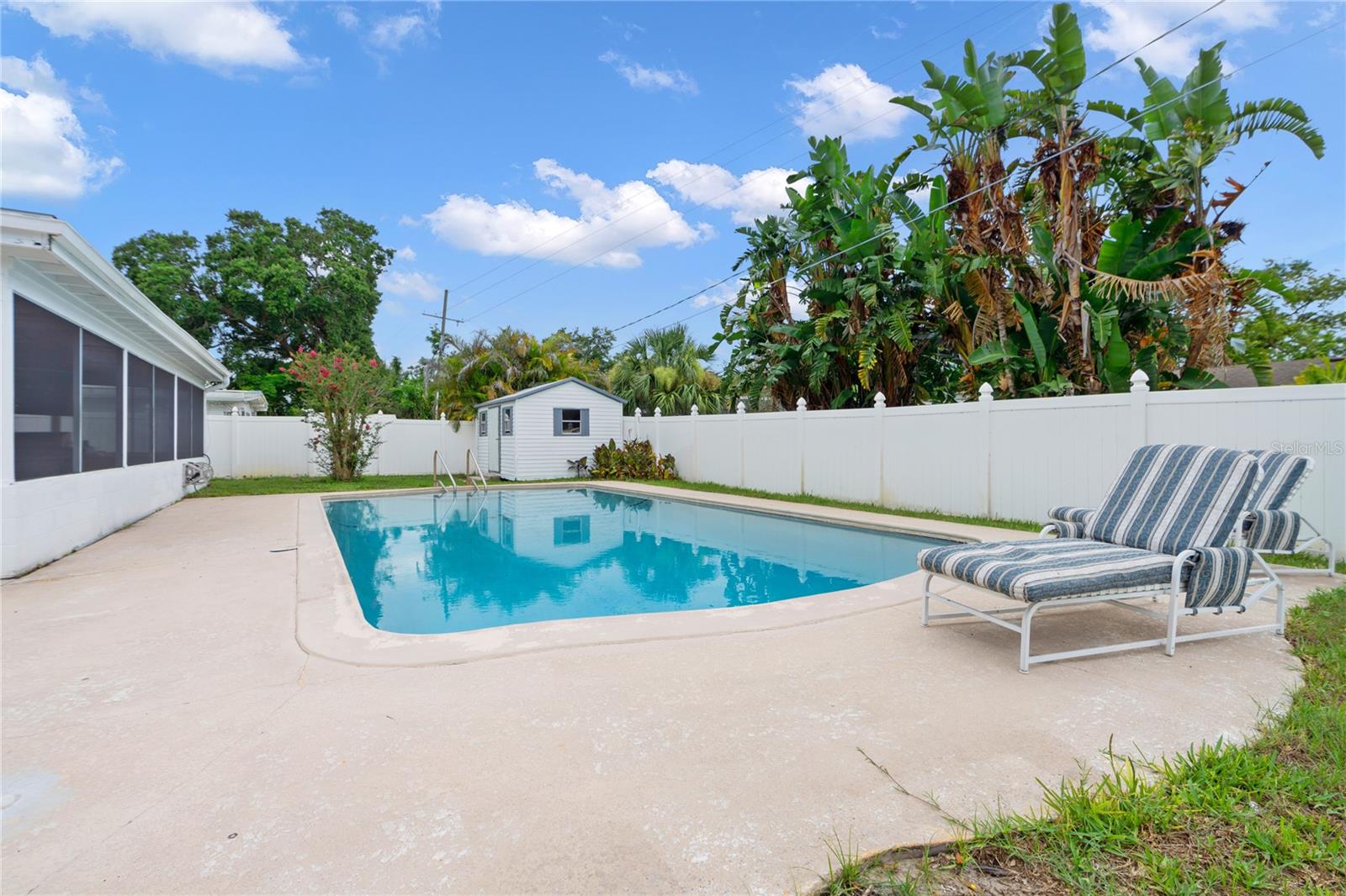 Large fenced in back Yad with a pool