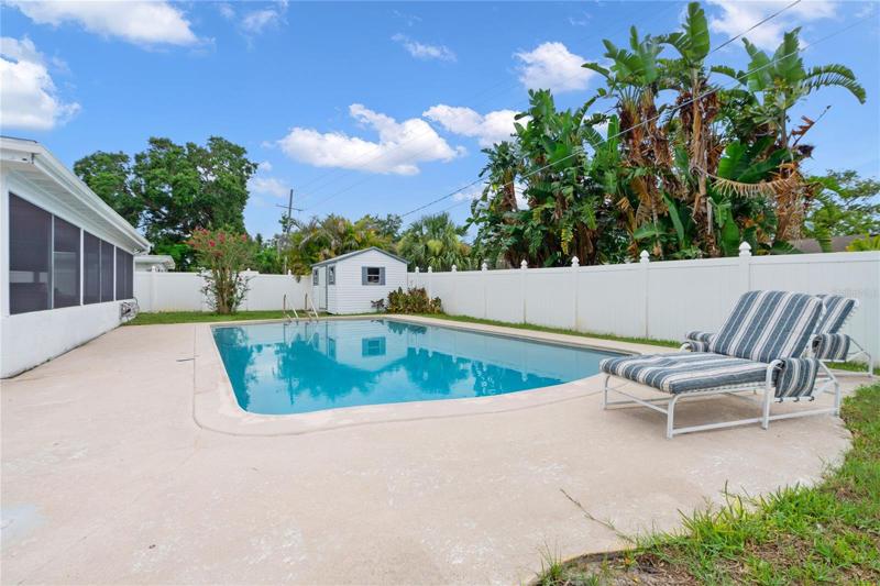 Large fenced in back Yad with a pool