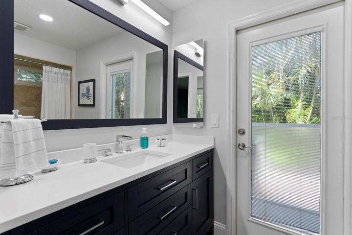 The 3rd full bath includes an updated vanity with quartz counters and doubles as a pool bath with direct access to the lanai
