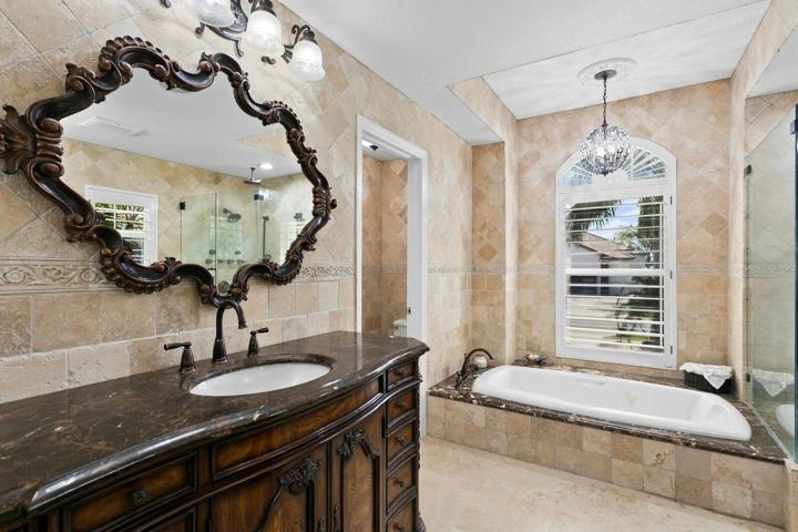 The master bath features travertine floors and dual vanities