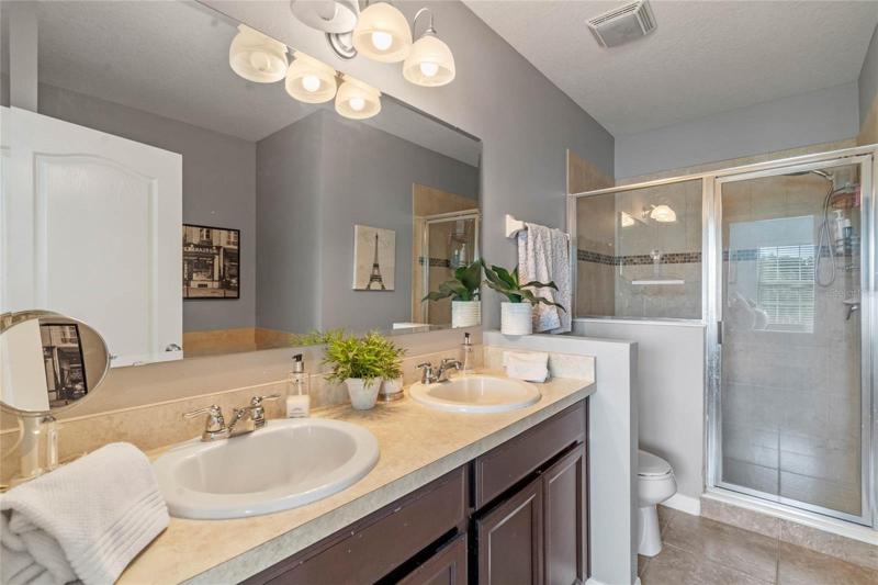 En-suite master bath with double sink vanity and walk-in shower.