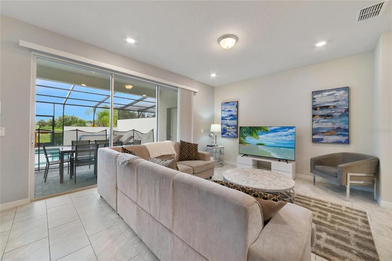 The living and dining spaces offer an ideal space to gather with family or entertain friends with TRIPLE SLIDING GLASS doors that access the lanai and pool for true indoor/outdoor living!