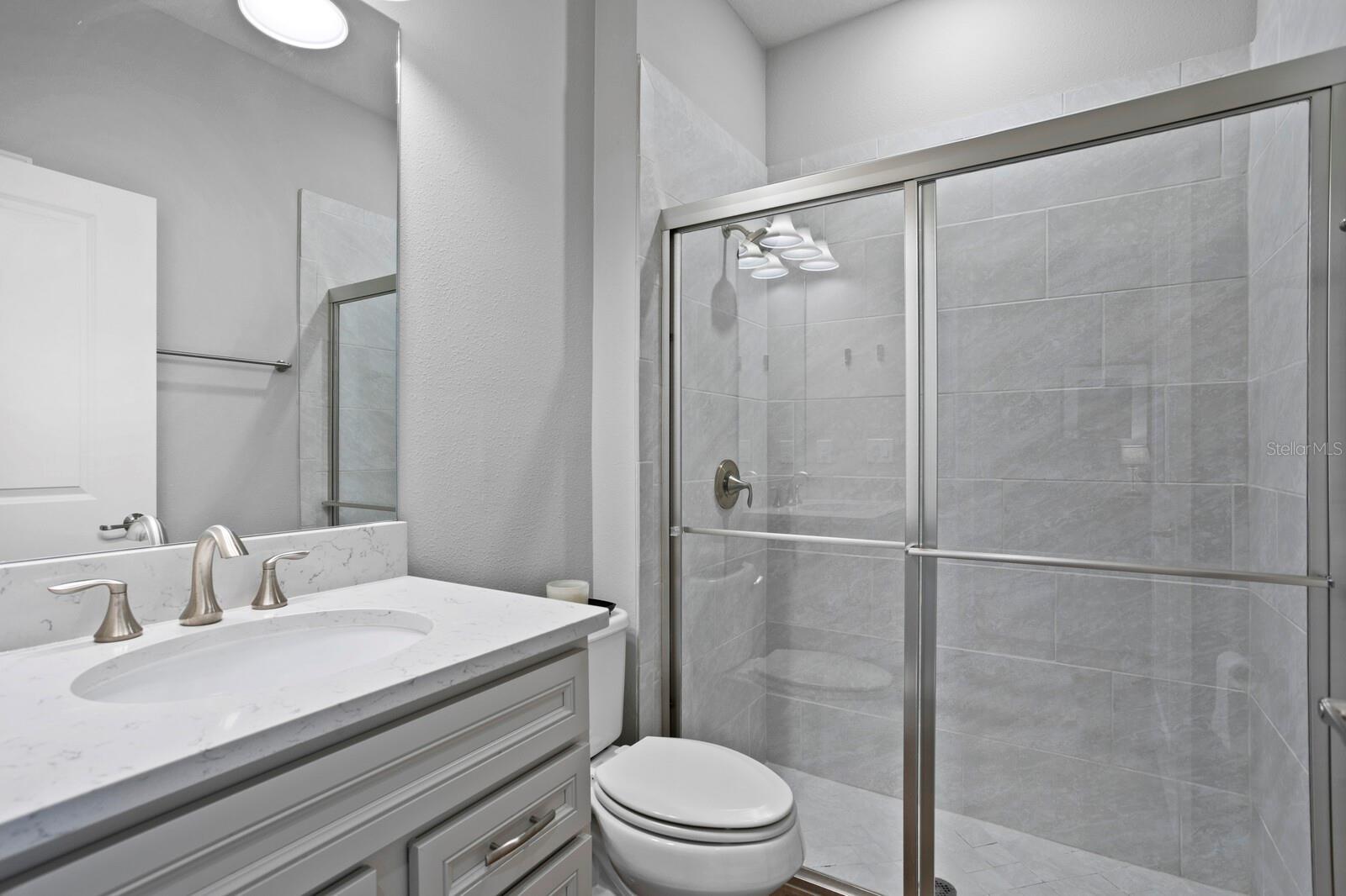 The 1st floor full bath includes a walk-in shower and quartz counters