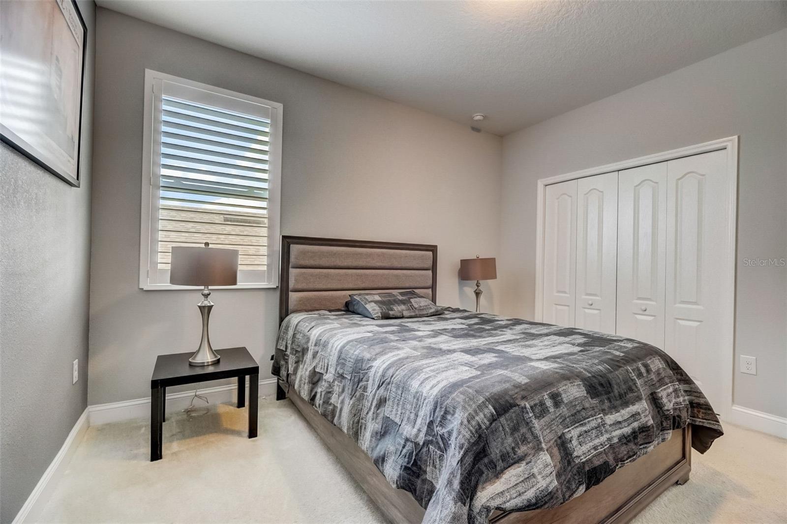 Prepare to awaken to the beauty of natural light gently illuminating your spacious bedroom, enhanced by the presence of upgraded plantation shutters. Embrace the calming and inviting ambiance, allowing the sun's radiance to fill your personal sanctuary with warmth and serenity.