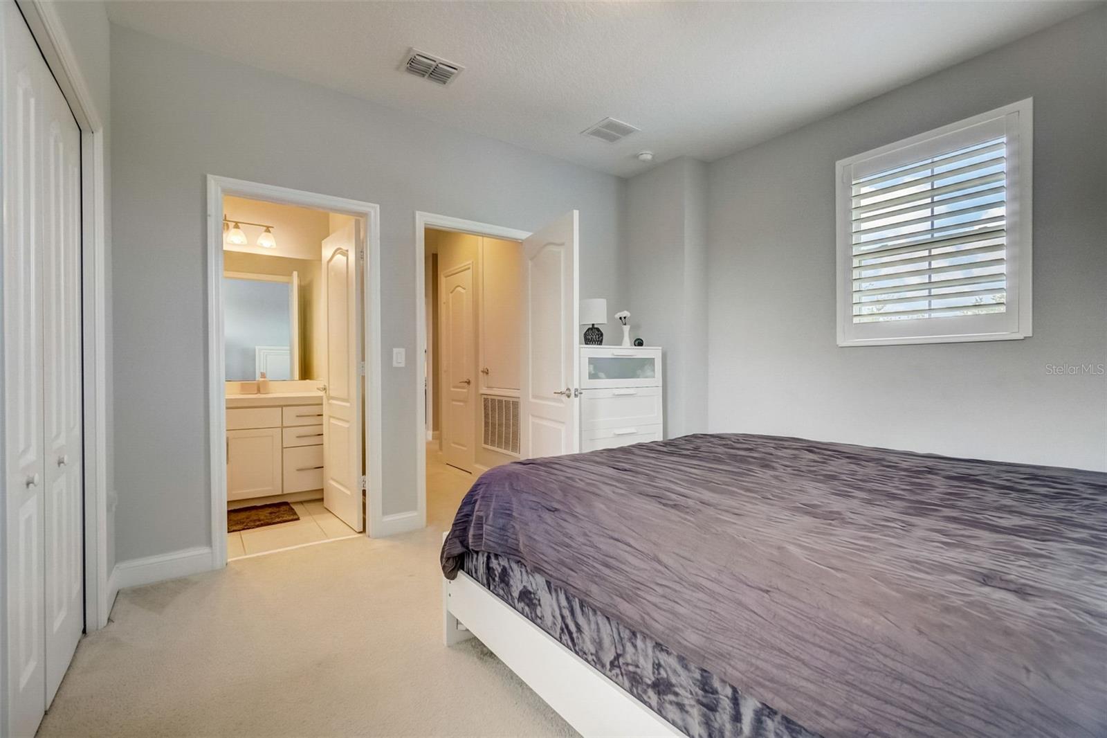 This bedroom becomes a serene retreat, inviting you to relax and unwind in a natural haven. The combination of the room's generous size, the welcoming natural light, and the upgraded plantation shutters harmonize to create an atmosphere that promotes peaceful slumber and rejuvenation.