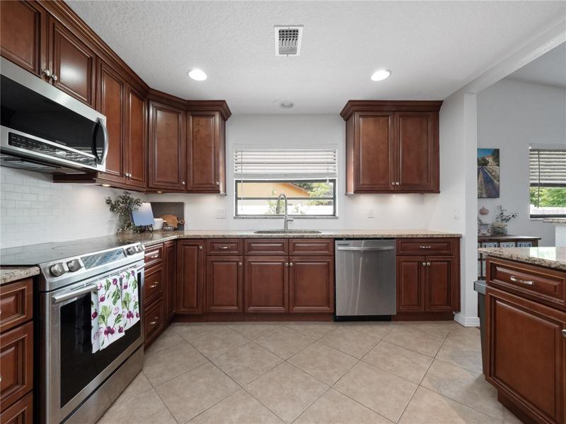 The oversized  kitchen has been updated with solid granite countertops, a large breakfast bar to gather around with seating for 3 and newer stainless steel appliances.