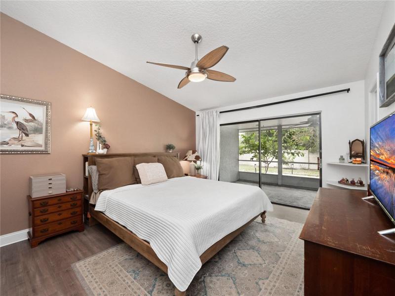 The primary suite has updated flooring, a walk in closet, access to the covered, screened in lanai and large backyard. The primary en-suite bathroom has been updated with solid wood dual sink vanity topped with granite along with a walk in shower.
