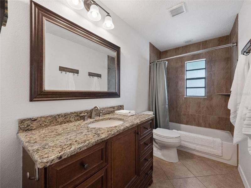 The hall guest bath with solid cabinets, granite counter tops and walk in bath/shower combination.