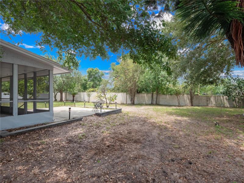 Fully fenced large backyard with fruit trees, enclosed lanai and two concrete patios.