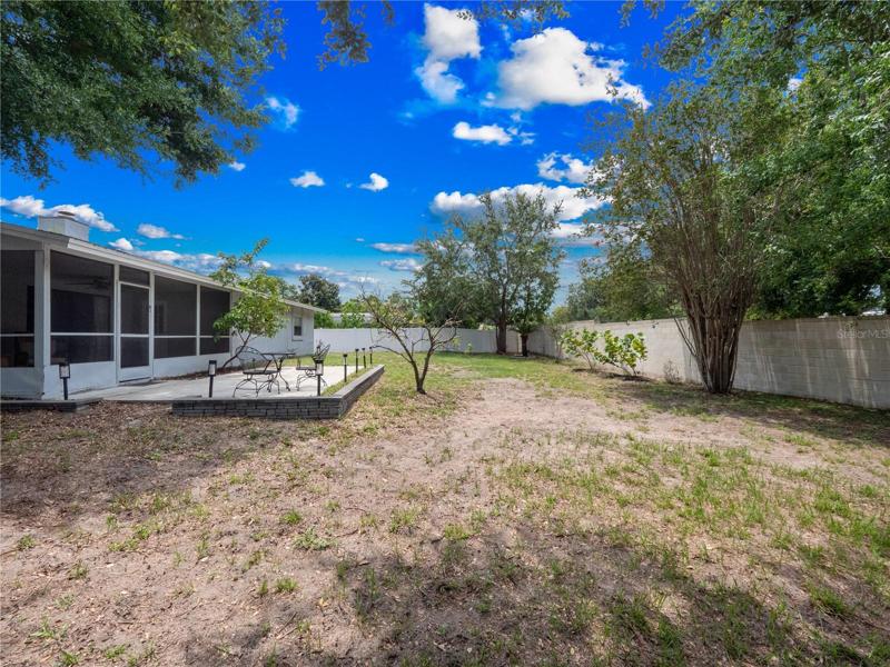 LaFully fenced large backyard with fruit trees, enclosed lanai and two concrete patios.