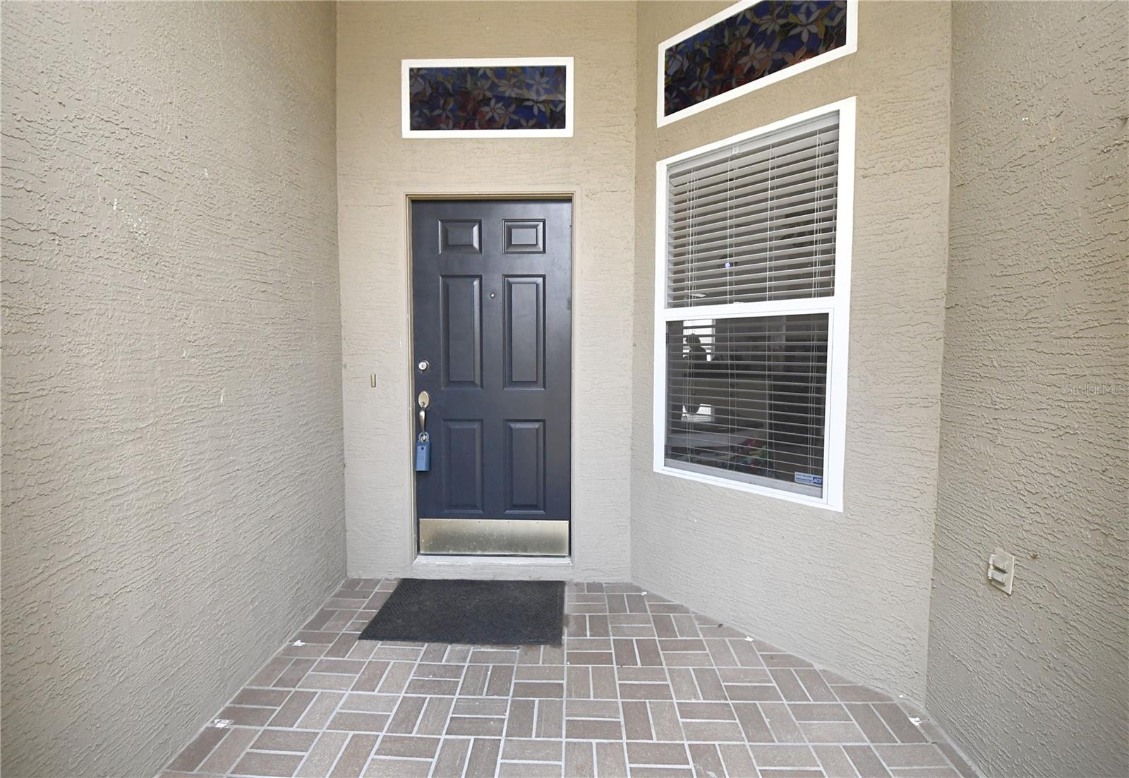 Brick paved, covered entryway.