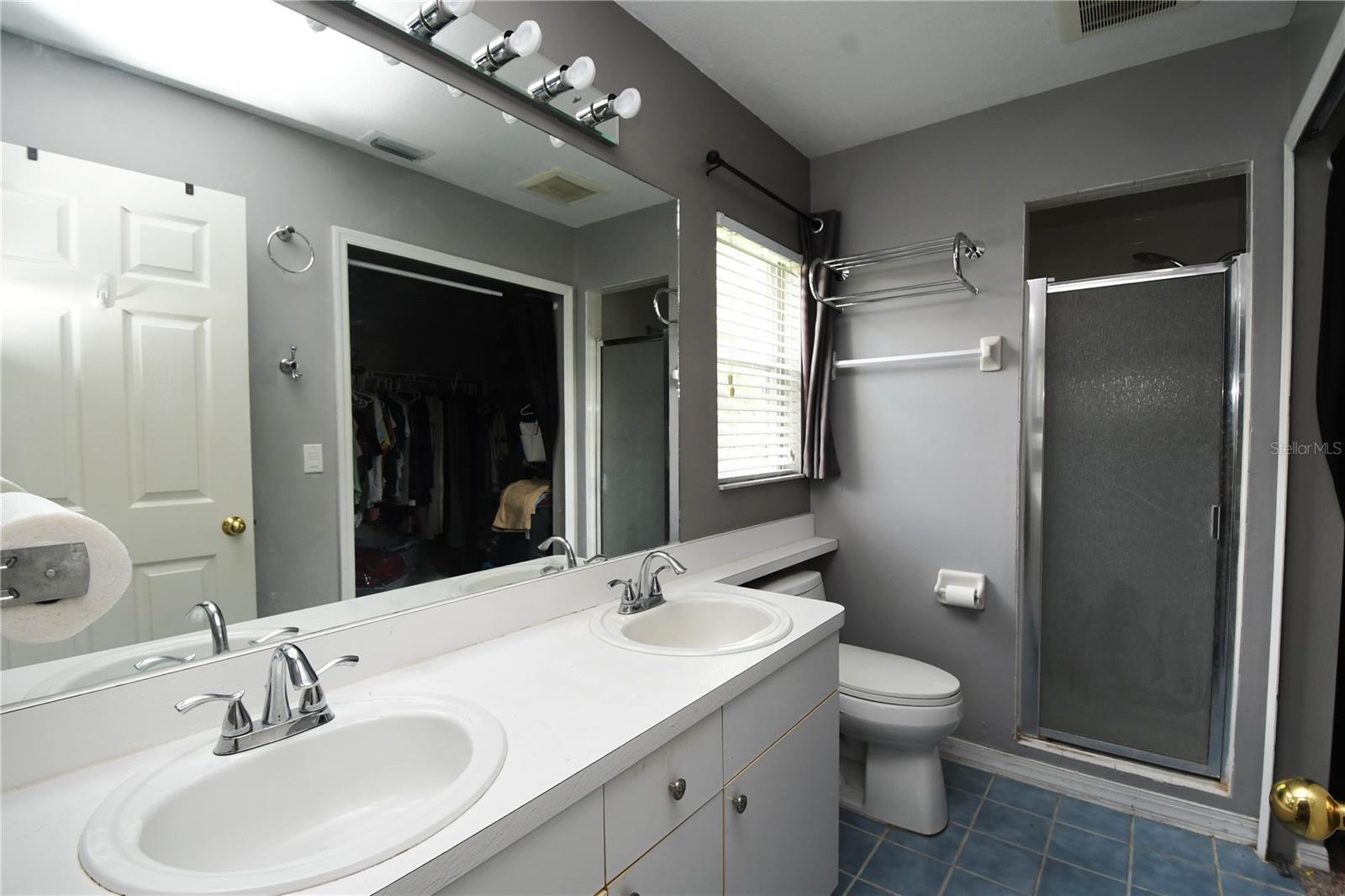 The master ensuite bath features a double sink, mirrored vanity with storage and a walk-in shower.