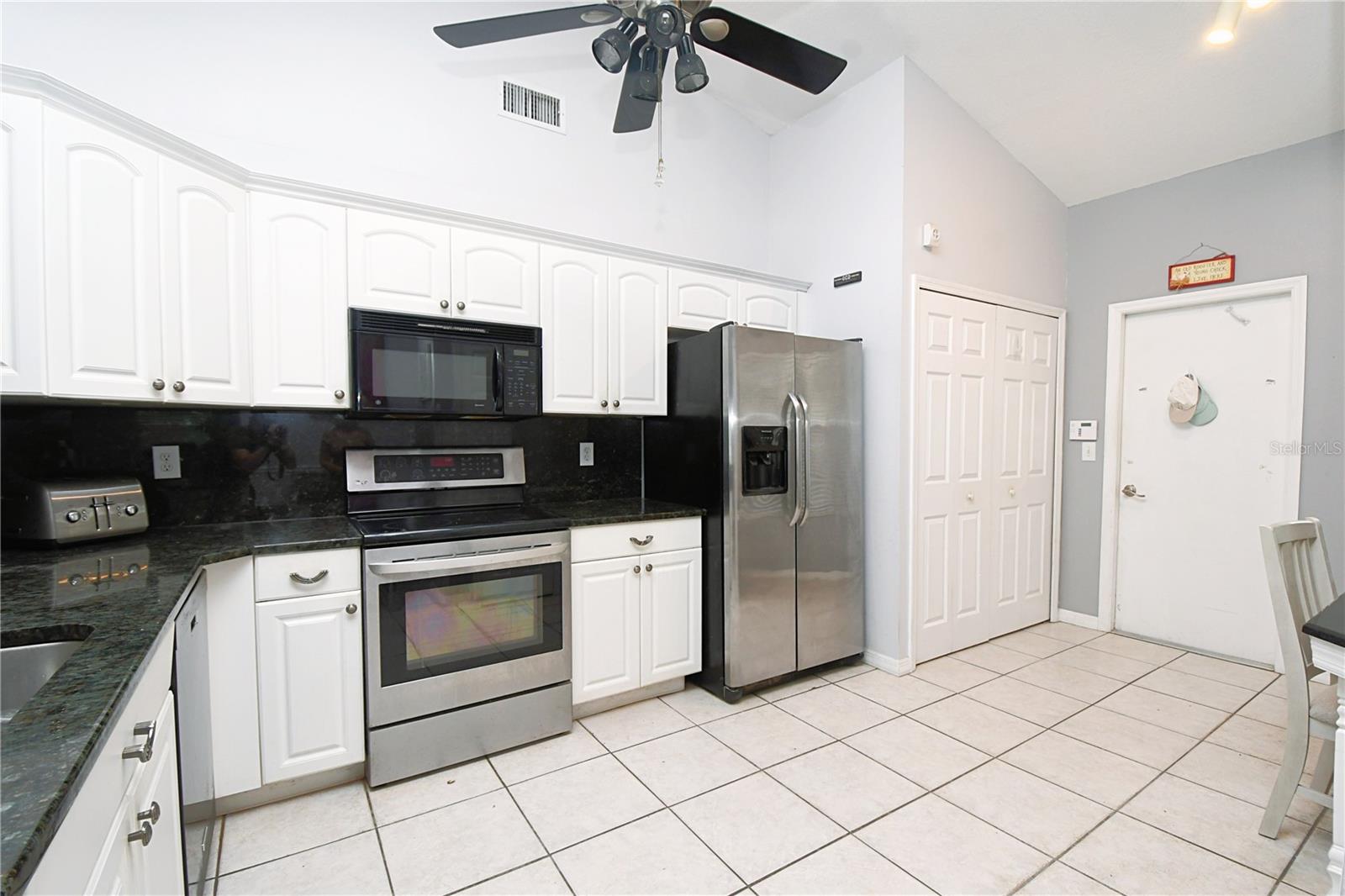 The kitchen boasts raised panel kitchen cabinets with crown molding, and granite countertops.