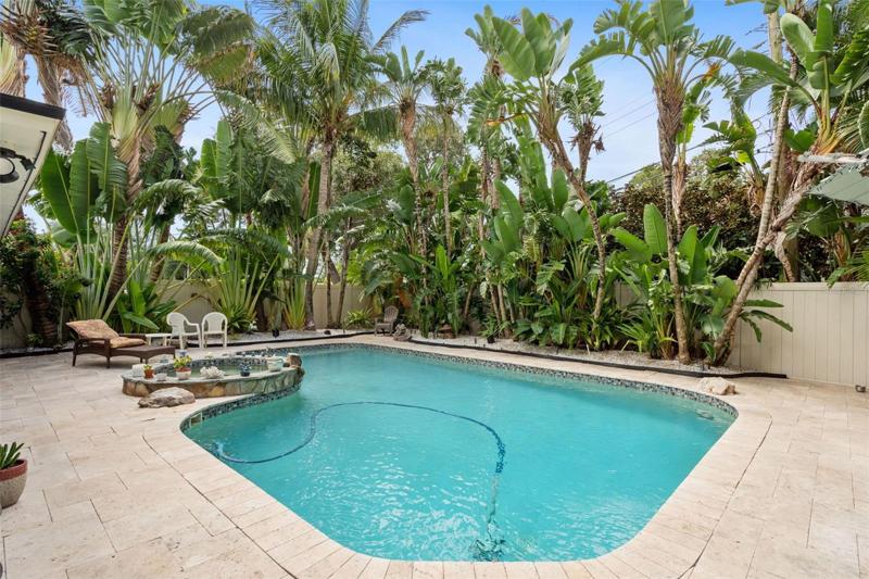 A saltwater pool and spa are surrounded by brick pavers