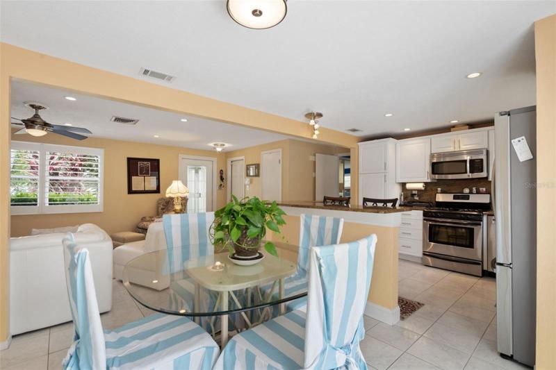 Kitchen, living and dining - open concept plans. Notice the plantation shutters and lovely landscaping looking out the living room window.
