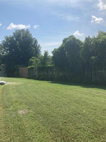 Large grass area behind the fenced pool outside of the vinyl fencing. Great buffer between homes to the side and rear.
