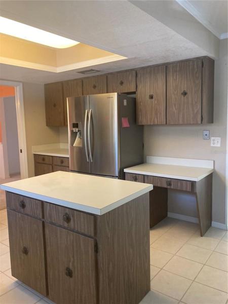 Another view of kitchen with side counter and desk area. French door  stainless steel frig.
