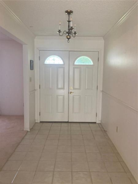 Long foyer with double wood entry doors.