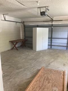 Garage with cabinet (which will be moved back to wall soon). Garage door opener.